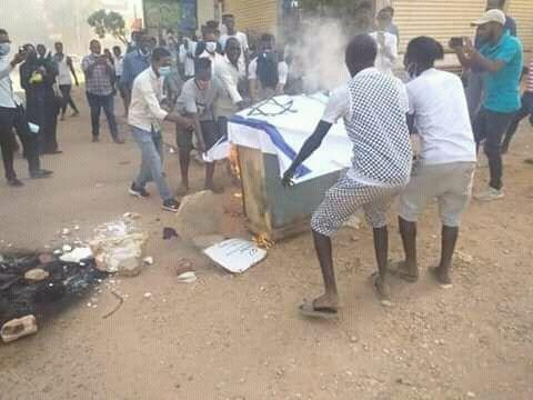 السودان: متظاهرون يحرقون علم 